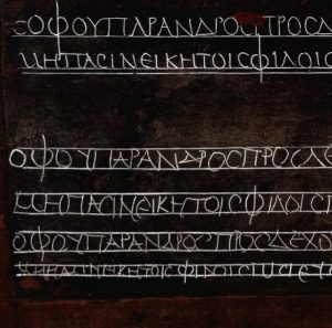 Ancient Greek handwritten text on a chalkboard for language learning.