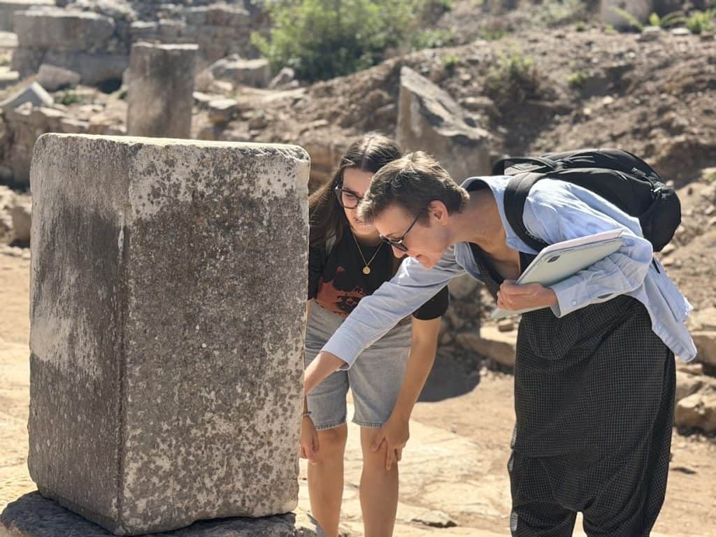 Our students reading a Greek inscription at Ephesus