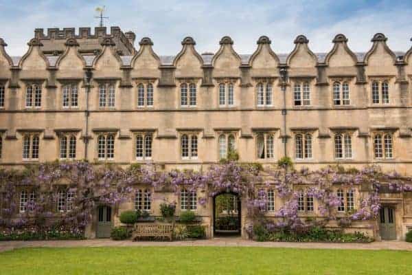 Oxford college building with purple flowering vines and Gothic architecture.